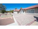 Spacious backyard patio area with decorative paving and custom retaining walls surrounding the home's perimeter at 8340 W Fisher Ave, Las Vegas, NV 89149