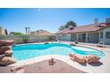 Backyard pool with rock features and a mature privacy hedge creating a relaxing backyard oasis at 8340 W Fisher Ave, Las Vegas, NV 89149