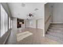 Bright, open living room with tile floors, ceiling fans, and staircase to the second floor at 9004 Snowtrack Ave, Las Vegas, NV 89149