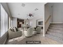 Bright, open living room with tile floors, ceiling fans, and staircase to the second floor at 9004 Snowtrack Ave, Las Vegas, NV 89149