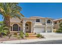 Attractive two-story home featuring a stucco exterior, tile roof, three-car garage, and verdant landscaping at 9208 November Breeze St, Las Vegas, NV 89123