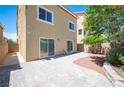 Paver patio, minimal landscaping, and tan stucco exterior of a two story home under a blue sky at 9450 Niagara Landing St, Las Vegas, NV 89139