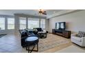 Inviting living area with large windows, tile floors, media center, and a cozy sectional sofa at 10372 Premia Pl, Las Vegas, NV 89135