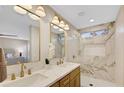 Elegant bathroom with double sinks, gold fixtures, and a stunning marble-tiled shower with built-in niche at 10886 Porto Foxi St, Las Vegas, NV 89141