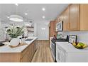 Modern kitchen with stainless steel appliances, an island with seating, and contemporary light fixtures at 10886 Porto Foxi St, Las Vegas, NV 89141