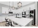 Well-lit kitchen with an island, white cabinets, modern appliances, and stylish black and white bar stools at 10968 Tracy Stevens Ave, Las Vegas, NV 89166