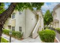 View of a two-story condo building with an exterior staircase, small green bushes and a streetlight at 1420 Red Crest Ln # 202, Las Vegas, NV 89144