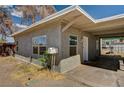 Side view of home with stucco exterior, covered parking area and simple landscaping at 155 Magnesium St, Henderson, NV 89015