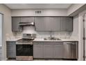 Updated kitchen with stainless steel appliances, white countertops, and gray cabinetry at 155 Magnesium St, Henderson, NV 89015