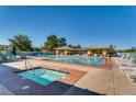 Community pool and spa area with plenty of lounge chairs and shaded seating under pergolas at 2105 Poppywood Ave, Henderson, NV 89012