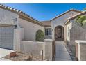 Inviting home exterior with a tiled roof, desert landscaping, and a decorative gated entryway at 2372 Perrysburg Dr, Henderson, NV 89044