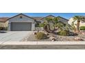 Beautiful single-story home featuring a two-car garage, desert rock yard and a well manicured lawn at 2372 Perrysburg Dr, Henderson, NV 89044