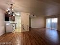 Living room featuring wood floors, sliding glass doors, and open access to the kitchen at 2606 S Durango Dr # 172, Las Vegas, NV 89117