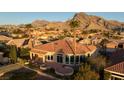 Sprawling single-story home with a tile roof and a large patio, set against a backdrop of majestic mountains at 2742 Darby Falls Dr, Las Vegas, NV 89134
