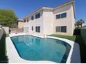 Backyard features a private swimming pool, lush green lawn, and a stylish stucco exterior at 2873 Cambretto Dr, Henderson, NV 89074