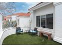 Cozy outdoor patio area with artificial turf, seating, white fence, and the home's exterior in the background at 3008 Blue Fin Cir, Las Vegas, NV 89128