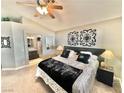 Cozy bedroom with a comfortable bed, decorative wall art, and a view into an en-suite bathroom at 3329 Hidden Ridge St, Las Vegas, NV 89129