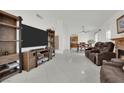Open-concept living room with a fireplace, mounted flat screen TV and easy access to dining area at 5512 Kettering Pl, Las Vegas, NV 89107