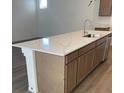 Spacious kitchen island featuring a stainless steel sink, storage cabinets, and a stone countertop at 6574 Tumoulin St, Las Vegas, NV 89148