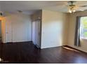 Bright living room featuring dark wood floors, a ceiling fan, and natural lighting at 6955 N Durango Dr # 1038, Las Vegas, NV 89149