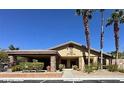 Clubhouse with covered parking, desert landscaping, and mature palm trees against a clear blue sky at 7300 Pirates Cove Rd # 2045, Las Vegas, NV 89145