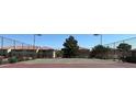 Outdoor tennis court surrounded by a chain-link fence and mature shade trees on a sunny day at 7300 Pirates Cove Rd # 2045, Las Vegas, NV 89145
