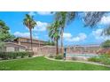 Community pool surrounded by grass and palm trees on a sunny day at 7300 Pirates Cove Rd # 2045, Las Vegas, NV 89145
