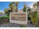 A welcoming entrance to the Pelican Point community featuring a stone sign surrounded by lush greenery and rocks at 8052 Marbella Cir, Las Vegas, NV 89128