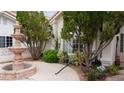 Front entrance adorned with mature landscaping, offering privacy and curb appeal at 8052 Marbella Cir, Las Vegas, NV 89128