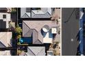 An aerial view showcases the home's roof, a nearby pool, and its neighborhood surroundings at 9858 Gemstone Sunset Ave, Las Vegas, NV 89148