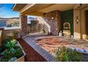 Inviting outdoor patio with stone columns, manicured greenery and a decorative water fountain at 9858 Gemstone Sunset Ave, Las Vegas, NV 89148