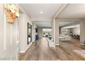 Open foyer with wood-look floors, neutral paint, modern decor, and views into the living and dining areas at 10086 Mountain Foothills Ave, Las Vegas, NV 89149