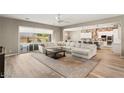 Spacious living room with a plush sectional, wood-look floors, and open access to the kitchen and backyard at 10086 Mountain Foothills Ave, Las Vegas, NV 89149