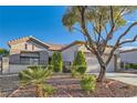 Beautiful single-story home with manicured landscaping, a tile roof, and a spacious two-car garage at 10309 Broom Hill Dr, Las Vegas, NV 89134