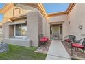 Inviting front entrance with seating, a decorative wreath, and well-maintained landscaping at 10309 Broom Hill Dr, Las Vegas, NV 89134