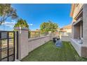 Attractive front yard with artificial grass and wrought iron gate to the walkway at 10309 Broom Hill Dr, Las Vegas, NV 89134