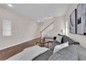 Spacious living room featuring a modern sofa, wooden floors, staircase with white railings, and neutral decor at 11164 African Sunset St, Henderson, NV 89052
