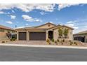 Inviting single-story home with a manicured front yard, desert landscaping, and a three-car garage at 1401 Cattail Falls St, Boulder City, NV 89005