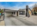 Cozy home with a covered carport, black trim, and a distinctive chimney design for added curb appeal at 1708 Poplar Ave, Las Vegas, NV 89101