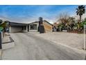 Attractive house featuring a carport, unusual chimney design, and well-maintained landscaping with a gated yard at 1708 Poplar Ave, Las Vegas, NV 89101