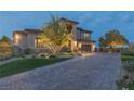 Stunning home featuring an expansive brick driveway, lush landscaping, and a well-maintained lawn at 2 Olympia Outlook Dr, Las Vegas, NV 89141