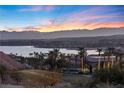 Sunset aerial view of a lakeside neighborhood with palm trees and mountain views at 20 Via Visione # 104, Henderson, NV 89011