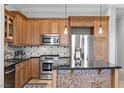 Modern kitchen with stainless steel appliances, granite counters, and custom cabinets at 20 Via Visione # 104, Henderson, NV 89011