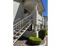 Exterior view of a two story condo building with white stucco and access stairs to upper units at 2713 Otter Creek Ct # 202, Las Vegas, NV 89117