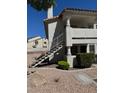 Exterior view of a two story condo building with white stucco and access stairs to upper units at 2713 Otter Creek Ct # 202, Las Vegas, NV 89117