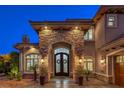 An elegant stone archway highlights double doors to the home at 3051 Traverse Creek Ln, Las Vegas, NV 89135