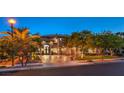 An opulent home with a circular driveway and lavish landscaping creates curb appeal at dusk at 3051 Traverse Creek Ln, Las Vegas, NV 89135