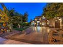 The stone archway frames double doors, inviting entry to a luxurious home with ample parking at 3051 Traverse Creek Ln, Las Vegas, NV 89135