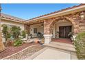 Inviting entrance with a stone archway, a covered porch, and a cozy seating area at 3290 Vicki Ave, Las Vegas, NV 89139