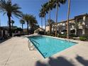 Sparkling community pool with clear blue water and lush palm tree landscaping at 3400 Cabana Dr # 1033, Las Vegas, NV 89122
